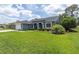 Beautiful property featuring a lush green lawn, enhanced landscaping, and an attached two-car garage at 13524 Knotty Ln, Hudson, FL 34669