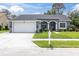 Charming single-story home featuring a well-manicured lawn and an attached two-car garage at 13524 Knotty Ln, Hudson, FL 34669