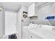 Functional laundry room with a washer, dryer, and overhead storage at 13524 Knotty Ln, Hudson, FL 34669