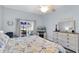 Cozy main bedroom featuring a ceiling fan, patio access, and warm decor at 13524 Knotty Ln, Hudson, FL 34669