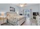 Spacious main bedroom with a ceiling fan, a patio door, and stylish furnishings at 13524 Knotty Ln, Hudson, FL 34669
