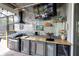 Outdoor kitchen featuring a built-in grill, countertop space, and beverage cooler at 13524 Knotty Ln, Hudson, FL 34669