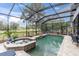 Enclosed pool and spa with brick patio and landscaping at 13524 Knotty Ln, Hudson, FL 34669