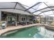 Screened pool with spa, outdoor kitchen, and ample seating at 13524 Knotty Ln, Hudson, FL 34669