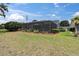 Relaxing screened patio with beautiful landscaping and an American flag waving in the breeze at 13524 Knotty Ln, Hudson, FL 34669