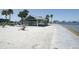 Picturesque waterfront park featuring a sandy beach, shaded picnic area, and calm bay waters at 13524 Knotty Ln, Hudson, FL 34669