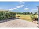 Backyard with brick patio, green hedge row, and a view of the golf course at 1420 Winding Willow Dr, Trinity, FL 34655