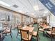 Well-lit card room featuring tables, chairs, and shuttered windows with a view of the water at 1420 Winding Willow Dr, Trinity, FL 34655
