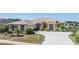 Charming single-story home featuring an arched entryway, lush landscaping, and a spacious driveway on a sunny day at 1420 Winding Willow Dr, Trinity, FL 34655