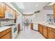 Bright kitchen featuring white appliances, wooden cabinets, and an adjacent breakfast nook with backyard views at 1420 Winding Willow Dr, Trinity, FL 34655