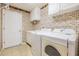 Laundry room featuring tile floors, patterned wallpaper, washer and dryer hookups, and white cabinets at 1420 Winding Willow Dr, Trinity, FL 34655