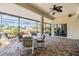 Enclosed patio area offering tiled floors, a ceiling fan, an outdoor table and seating with views of the backyard at 1420 Winding Willow Dr, Trinity, FL 34655