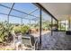 Relaxing screened patio showcasing tiled floors, comfortable seating and views of the landscaped backyard at 1420 Winding Willow Dr, Trinity, FL 34655