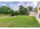 A view of the backyard with a picturesque pond, lush greenery, and part of the home's exterior at 15906 Prince William Pl, Odessa, FL 33556