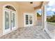 Outdoor balcony with elegant columns, tile flooring, and a decorative front door at 15906 Prince William Pl, Odessa, FL 33556
