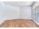 Bright bedroom with a large window featuring plantation shutters and stylish wood-look flooring at 15906 Prince William Pl, Odessa, FL 33556
