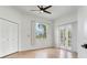 Bright bedroom featuring a ceiling fan, closet, french doors, and wood flooring at 15906 Prince William Pl, Odessa, FL 33556