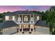 Elegant two-story home featuring white columns, a balcony, a dark roof, and a three-car garage at 15906 Prince William Pl, Odessa, FL 33556