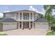 Elegant home featuring stately columns, a balcony, and a circular driveway, surrounded by lush landscaping at 15906 Prince William Pl, Odessa, FL 33556