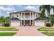 Traditional two-story home with a brick driveway, three-car garage, and manicured landscaping at 15906 Prince William Pl, Odessa, FL 33556