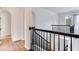Hallway featuring wood floors, black railing, archways, and a door leading to a room at 15906 Prince William Pl, Odessa, FL 33556