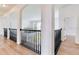 Upstairs hallway with wood floors, arches, black wrought iron railing, and an open and airy feel at 15906 Prince William Pl, Odessa, FL 33556