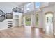 Spacious living room featuring high ceilings, large windows, and a staircase with black iron railings at 15906 Prince William Pl, Odessa, FL 33556