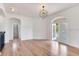 Spacious living room featuring wood floors, arched doorways and a modern light fixture at 15906 Prince William Pl, Odessa, FL 33556