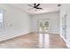 Living room featuring wood floors, a ceiling fan, windows and a door leading to a balcony at 15906 Prince William Pl, Odessa, FL 33556