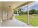 Covered patio with view of pond, lush greenery, and manicured lawn at 15906 Prince William Pl, Odessa, FL 33556
