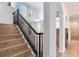 Elegant staircase featuring wood steps, black railings, and a view into the bright, open living space at 15906 Prince William Pl, Odessa, FL 33556