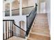 Elegant staircase featuring wood steps and black wrought iron railing, leading to the upper level at 15906 Prince William Pl, Odessa, FL 33556