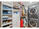 Well-organized closet with shelving, drawers, and laundry area featuring a stacked washer and dryer at 1700 Beachway Ln, Odessa, FL 33556