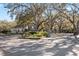 Community entrance featuring mature trees, landscaping, and gated access to the Holiday Club at 1700 Beachway Ln, Odessa, FL 33556