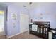 This cozy bedroom features ample light, a dark-wood crib, and comforting decorative features at 18061 Glastonbury Ln, Land O Lakes, FL 34638