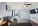 This bedroom offers a comfortable bed, ceiling fan, and a large window offering great natural lighting at 18061 Glastonbury Ln, Land O Lakes, FL 34638