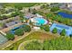 Aerial view of community amenities featuring a pool, playground, tennis courts, and ample parking at 18061 Glastonbury Ln, Land O Lakes, FL 34638