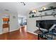 Inviting entryway featuring sleek, wood-look floors leading to the kitchen and dining area, with modern shelving and monitors at 18061 Glastonbury Ln, Land O Lakes, FL 34638
