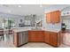 Open kitchen featuring a breakfast bar, stainless steel dishwasher, and views into the living and dining areas at 18061 Glastonbury Ln, Land O Lakes, FL 34638