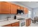 Close-up of the kitchen featuring white marble countertops, wood cabinets, and modern appliances at 18061 Glastonbury Ln, Land O Lakes, FL 34638