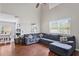 Comfortable living room featuring hardwood floors, a plush sofa, and large windows at 18061 Glastonbury Ln, Land O Lakes, FL 34638