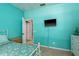 Bright bedroom featuring teal walls, a bed, and a mounted television for comfortable living at 1810 Winsloe Dr, Trinity, FL 34655