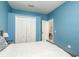 Blue bedroom features a large closet, a window with white curtains and a ceiling fan at 1810 Winsloe Dr, Trinity, FL 34655
