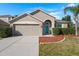 Charming single-Gathering home featuring a well-kept lawn, front shrubs, and an attached two-car garage at 1810 Winsloe Dr, Trinity, FL 34655