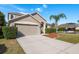 Inviting two-story home featuring a well-manicured lawn, mature landscaping, and an attached two-car garage at 1810 Winsloe Dr, Trinity, FL 34655