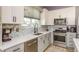 Kitchen features modern stainless steel appliances, white countertops, tile backsplash, and ample cabinet space at 1810 Winsloe Dr, Trinity, FL 34655