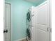 Functional laundry room with stacked washer and dryer units, along with ample storage cabinets at 1810 Winsloe Dr, Trinity, FL 34655