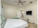 This spacious main bedroom features a ceiling fan and a door that opens to the ensuite bathroom at 1810 Winsloe Dr, Trinity, FL 34655