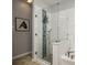 Modern bathroom featuring glass shower with decorative tile accent and updated fixtures at 1810 Winsloe Dr, Trinity, FL 34655