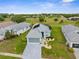 A light blue single-story home boasts a gray roof, two-car garage, manicured landscaping and backs up to a golf course at 18209 Breland Dr, Hudson, FL 34667